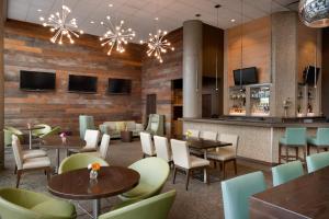 a restaurant with tables and chairs and a bar at Coast Chilliwack Hotel by APA in Chilliwack
