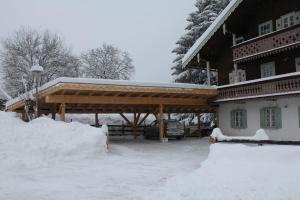 a snow covered house with a wooden roof at Villa Zeppelin - App Aquamarin in Bramberg am Wildkogel