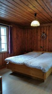 a bedroom with a bed in a wooden room at Villa Zeppelin - App Aquamarin in Bramberg am Wildkogel