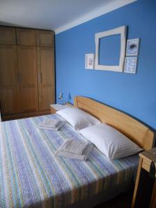 a blue bedroom with a bed with two pillows at Room Dinko in Valun