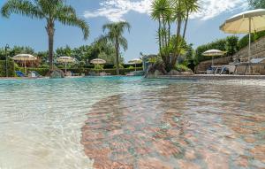 a swimming pool with trees and umbrellas at Residence Villa Rosi in Laureana Cilento
