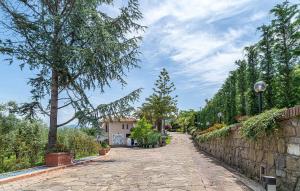 uma rua de calçada com árvores e uma parede de pedra em Residence Villa Rosi em Laureana Cilento