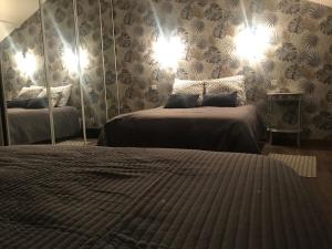 een slaapkamer met twee bedden en een spiegel bij l appart de Lilly in Pierry