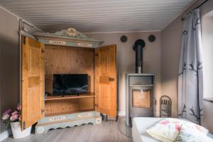 Schlafzimmer mit einem Bett, einem TV und einem Kamin in der Unterkunft Chalet am Hasensprung in Berchtesgaden