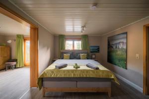 ein Schlafzimmer mit einem großen Bett mit gelber Tagesdecke in der Unterkunft Chalet am Hasensprung in Berchtesgaden