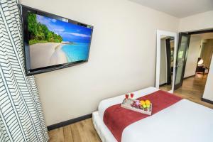 a hotel room with a flat screen tv on the wall at Metropole Suites South Beach in Miami Beach