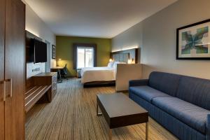 um quarto de hotel com uma cama e um sofá em Holiday Inn Express Hotel & Suites Austell Powder Springs, an IHG Hotel em Austell