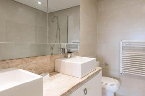 ein Badezimmer mit Waschbecken, Toilette und Spiegel in der Unterkunft Via Florida Luxo II - 303 in Gramado + 20 Fotos