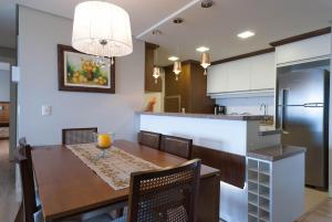 eine Küche und ein Esszimmer mit einem Tisch und einem Kühlschrank in der Unterkunft Via Florida Luxo II - 303 in Gramado