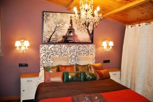 sypialnia z łóżkiem z obrazem wieży Eiffel w obiekcie Complejo Casas Rurales MANSIONES Y VILLAS DELUXE w mieście Collado Mediano +37 zdjęć