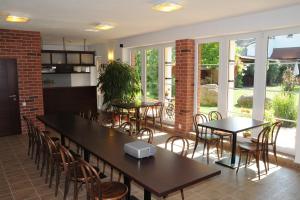 a dining room with tables and chairs and windows at Penzion Rondo in Bystřice pod Hostýnem