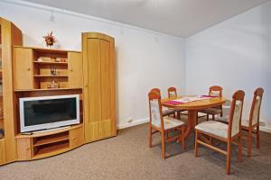 a dining room with a table and a tv at Ferienwohnung 143 in Annaberg-Buchholz