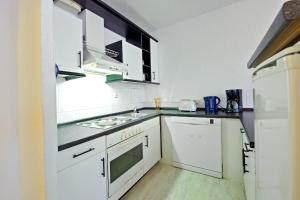 cocina con armarios blancos y fogones en Ferienwohnung 143 en Annaberg-Buchholz