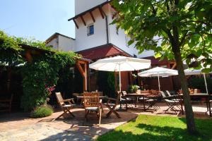 a patio with tables and chairs and umbrellas at Penzion Rondo in Bystřice pod Hostýnem