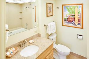 a bathroom with a sink and a toilet and a mirror at Aston Kaanapali Shores in Lahaina