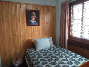 um quarto com uma cama e um quadro na parede em Casa Posada Amelia em Bogotá