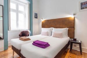 1 dormitorio con 2 camas y 1 silla en LV Premier Baixa DO en Lisboa