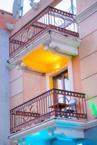 a balcony on a building with a table and a clock at Yiannis Apartments in Ioannina