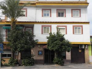 um grande edifício branco com árvores em frente em Hostal Santa Ana em San José de la Rinconada