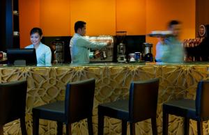 a man and a woman standing at a bar at Saray Musheireb Hotel Suites and Apartment in Doha