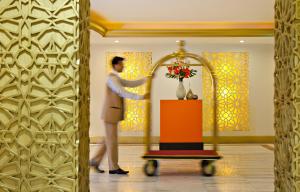 a man standing in front of a mirror in a room at Saray Musheireb Hotel Suites and Apartment in Doha