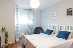 a bedroom with two beds and a chair at Apartament Koja in Giżycko