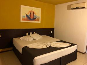 małe łóżko w pokoju z obrazem na ścianie w obiekcie Saint Patrick Praia Hotel w mieście Maceió