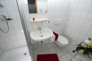 a bathroom with a sink and a toilet and a shower at Pension Cafe Suzette in Gotha +17 photos