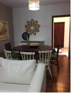 ein Wohnzimmer mit einem Tisch, Stühlen und einem Sofa in der Unterkunft Apartamento em Ubatuba, confortavel e bem localizado in Ubatuba