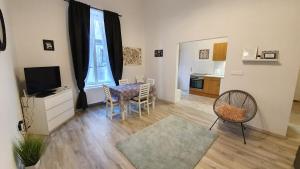 a living room with a television and a table and chairs at Előkapu Apartman in Sopron