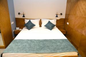 una camera da letto con un letto grande con due cuscini di R&R Hotel a Yerevan