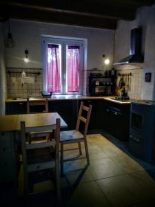 Ciuchi House في Cantalupo Ligure: مطبخ مع طاولة وكراسي ومغسلة
