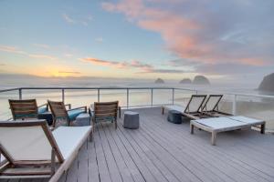 una terraza con sillas y mesas en la playa en The Oceanside Inn, en Oceanside