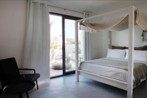 CarmianoにあるCorte Dei Grazianiのベッドルーム(白い天蓋付きベッド1台、椅子付)