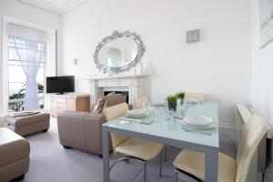 a white living room with a table and a couch at Seaview Regency Apartment in Torquay