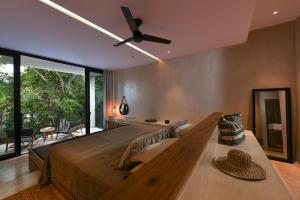 ein Schlafzimmer mit einem großen Bett und einem Deckenventilator in der Unterkunft Casa Agape Boutique Hotel Rooftop Pool & Beach club access in Tulum