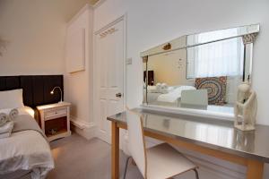 a bedroom with a desk and a bed with a mirror at Seaview Regency Apartment in Torquay