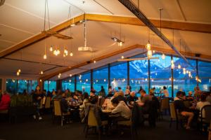 a group of people sitting at tables in a restaurant at Mt Cook Lodge and Motels in Mount Cook Village