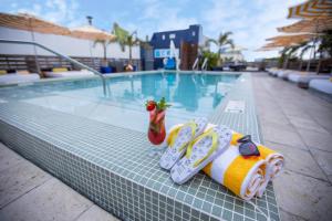 
a table topped with a surfboard next to a pool at Catalina Hotel & Beach Club in Miami Beach
