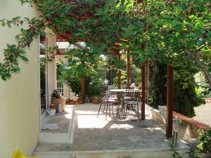 a patio with a table and chairs under a pergola at Apartments Mana - 250 m from sea in Split