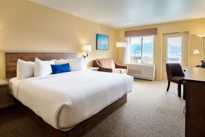 a hotel room with a large bed and a chair at Harbor 360 Hotel Seward in Seward