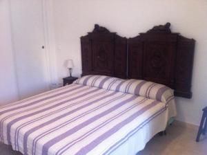 a bed with a wooden headboard in a bedroom at Emmevvì in Tropea