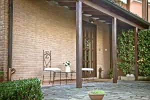 eine Terrasse mit 2 Stühlen und einem Tisch vor einem Backsteingebäude in der Unterkunft Borgo Manzoni - Charming House in Rozzano