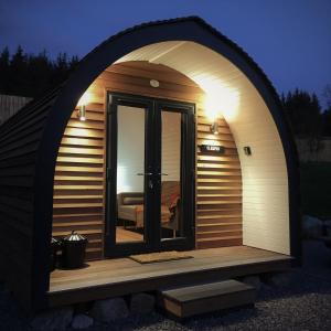 a large arched doorway to a sauna with a window at Tomatin Glamping Pods in Inverness