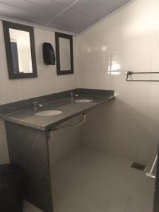 a bathroom with two sinks and two mirrors at HOSTEL DU SUCA in Petrópolis