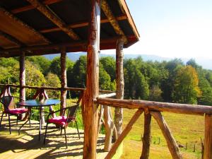 - une table et des chaises sur la terrasse couverte d'une cabine dans l'établissement Refugio de Montaña Kultrun Mawida, Cabaña Mirador, à Curacautín
