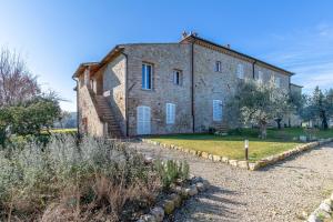 un ancien bâtiment en briques avec un escalier devant lui dans l'établissement Il Castro Luxury Apartments, à San Gimignano