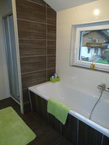 uma casa de banho com uma banheira e uma janela em Haus Zerza em Dorfgastein