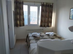 Salamandra Apartamentos في إل كالافاتي: غرفة صغيرة بسريرين ونافذة