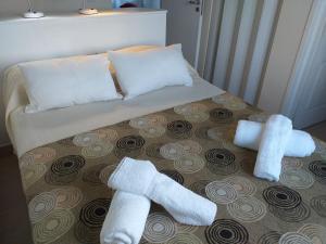 Una cama con dos rollos de toallas. en Salamandra Apartamentos en El Calafate